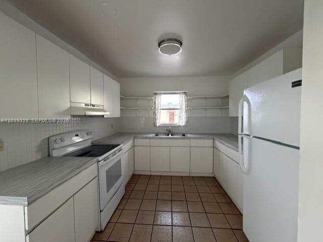 A kitchen features white cabinets, a white stove, a white refrigerator, and tiled flooring — 2128 Roosevelt St # 3, Hollywood FL 33020, HOLLYWOOD, FL