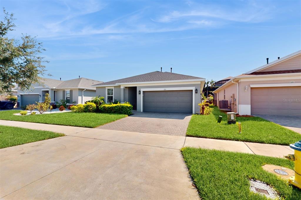 A single-story suburban house with a gray garage and a paved driveway — 626 CONSERVATION BOULEVARD, GROVELAND, FL