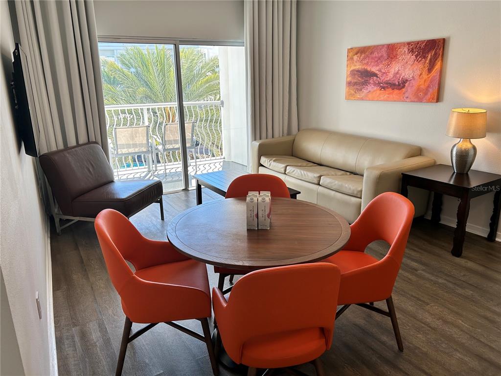 A living and dining area features a round table with orange chairs and a sofa — 225 CELEBRATION PLACE UNIT 446, KISSIMMEE, FL