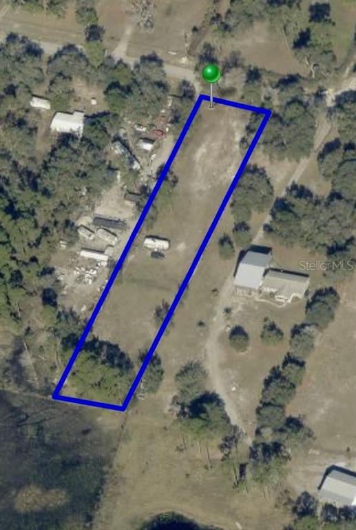 An aerial view shows a rectangular plot of land outlined in blue with scattered trees — 32402 PINE ROAD, EUSTIS, FL