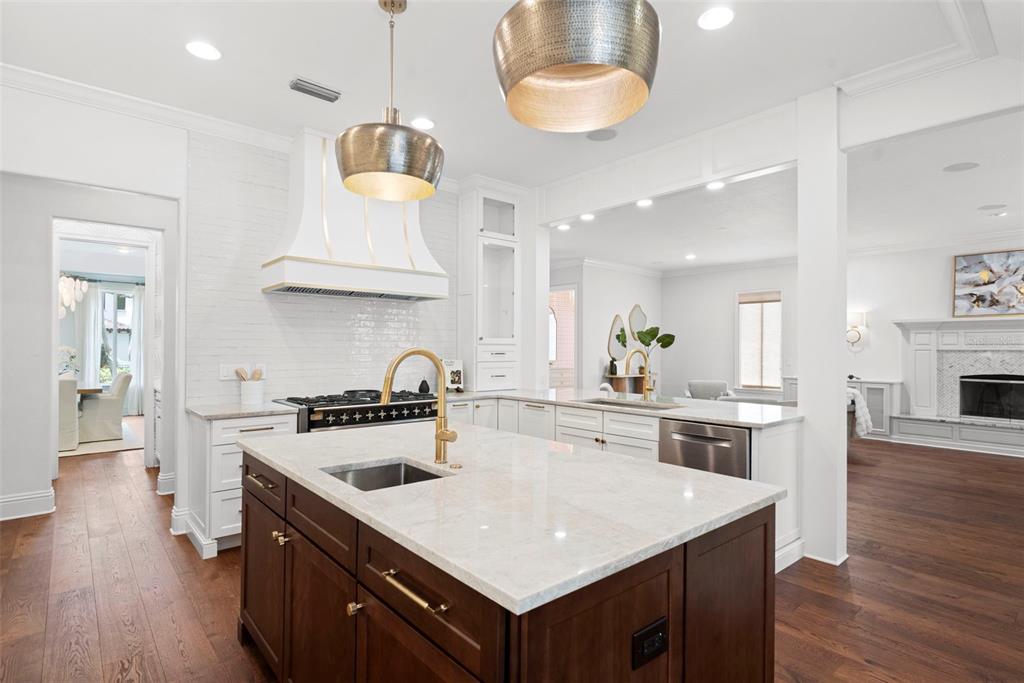A kitchen features a dark wood island with a stone countertop and white cabinetry — 4406 W AZEELE STREET, TAMPA, FL