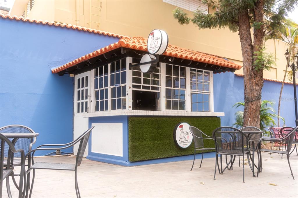 An outdoor kiosk with a tiled roof and green turf siding sits on a paved patio — 1 C. ISABEL MUÑOZ RIVERA, PONCE, PR