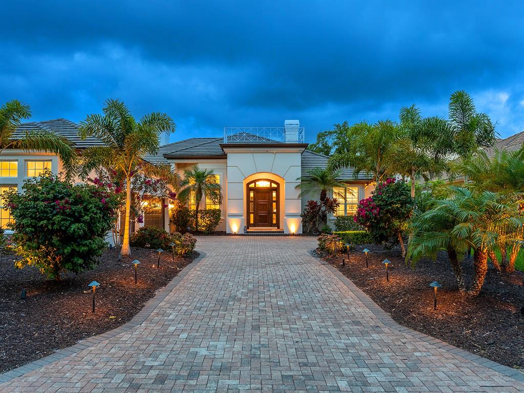 A paved driveway leads to the front entrance of a house with palm trees — 7431 GREYSTONE STREET, LAKEWOOD RANCH, FL