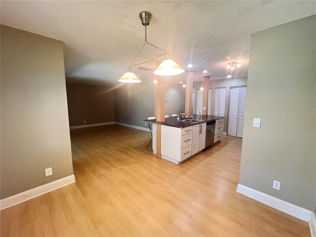A kitchen with a central island and pendant lighting opens into a spacious living area — 302 PALM COAST PARKWAY NE UNIT 204, PALM COAST, FL