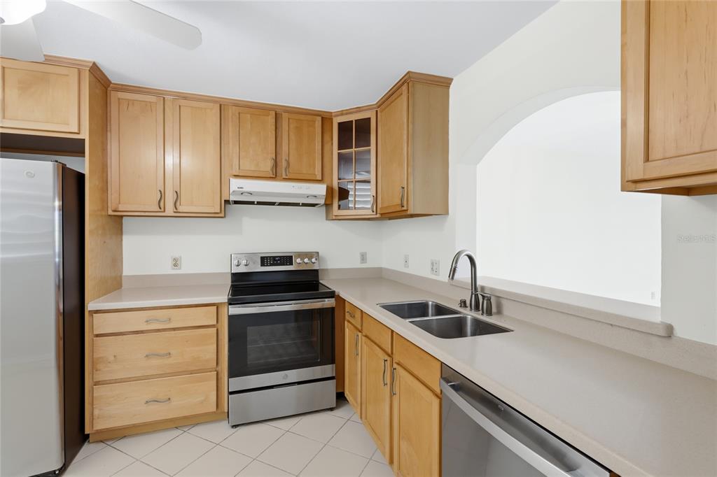 A kitchen with light wood cabinets, stainless steel appliances, and beige countertops — 211 LAKEWOOD DRIVE UNIT 211, BRADENTON, FL