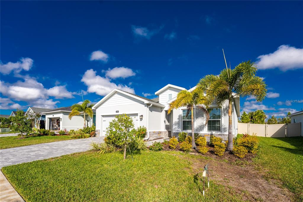 A single-story house with a paved driveway, palm trees, and a landscaped front yard — 16185 S PORT HARBOR BOULEVARD, PORT CHARLOTTE, FL