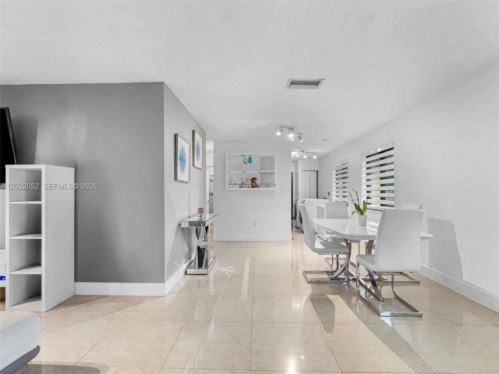 A dining area features a white table, modern chairs, and tile flooring — 1752 NW 108th St, Miami FL 33167, MIAMI, FL