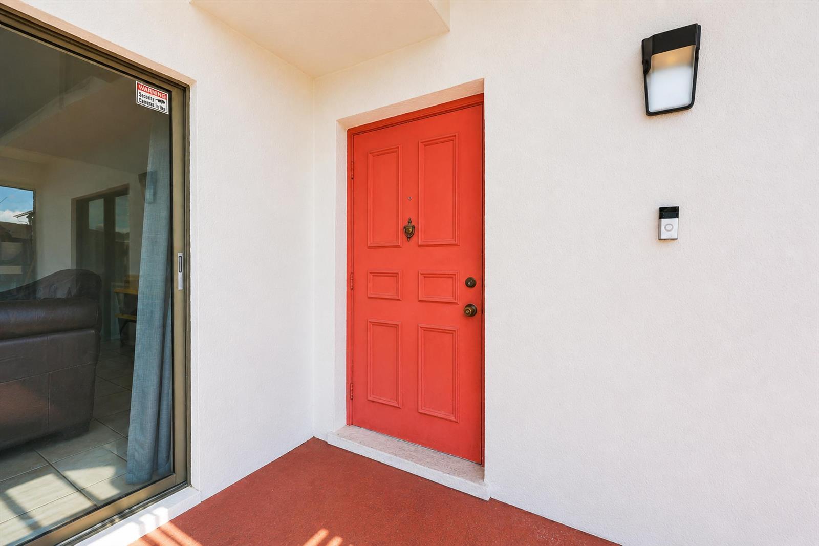 A bright red front door is set into a white wall next to a sliding door — 2716 Yale Lane, Boynton Beach FL 33426, BOYNTON BEACH, FL