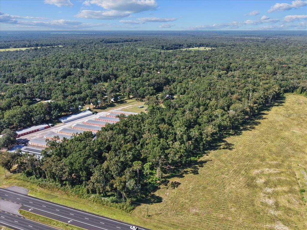 An aerial view shows a storage facility complex bordered by a highway and dense forest — NW US 19 HIGHWAY, FANNING SPRINGS, FL