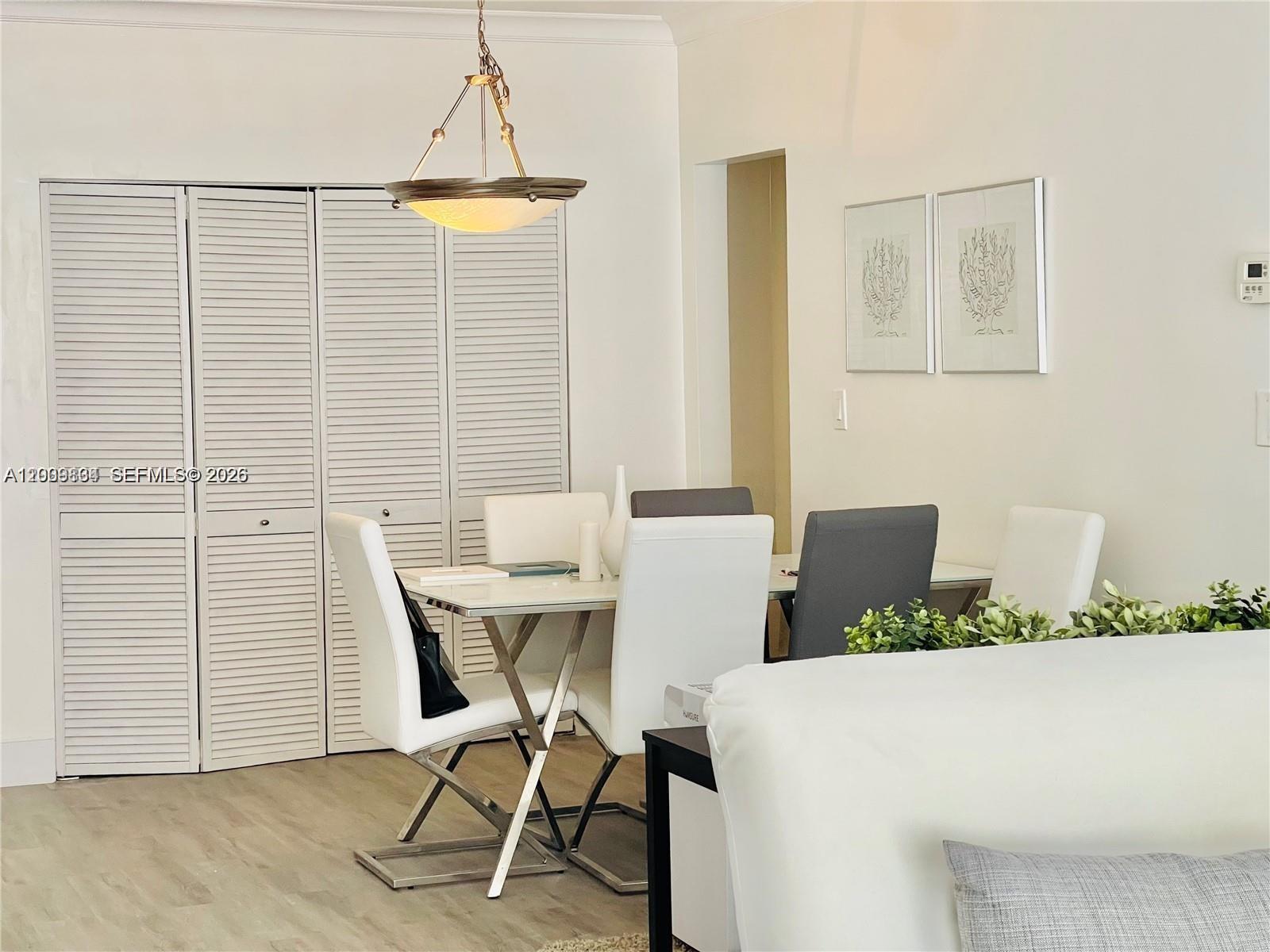 A dining area features a white table, modern chairs, and louvered closet doors — 3001 S Ocean Dr # 101, Hollywood FL 33019, HOLLYWOOD, FL