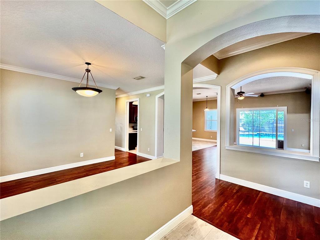 An interior view shows a dining area, a hallway, and a living room with pool views — 2848 DUNCAN TREE CIRCLE, VALRICO, FL