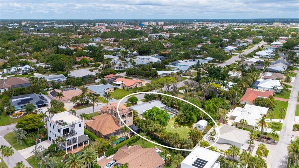 An aerial view shows a residential property with a large backyard and a swimming pool — 621 ALHAMBRA ROAD, VENICE, FL