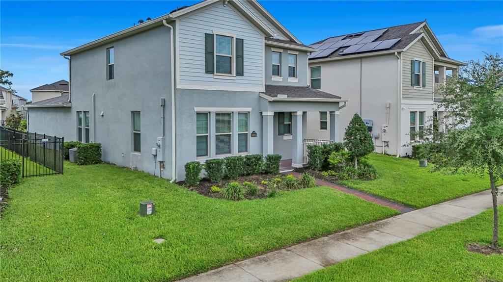 A two-story house with light blue siding and stucco exterior features a front porch — 16495 POINT ROCK DRIVE, WINTER GARDEN, FL