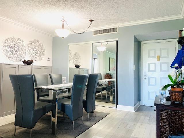 A dining room features a glass table, gray chairs, mirrored closet doors, and light flooring — 737 SE 1st Way # 306, Deerfield Beach FL 33441, DEERFIELD BEACH, FL