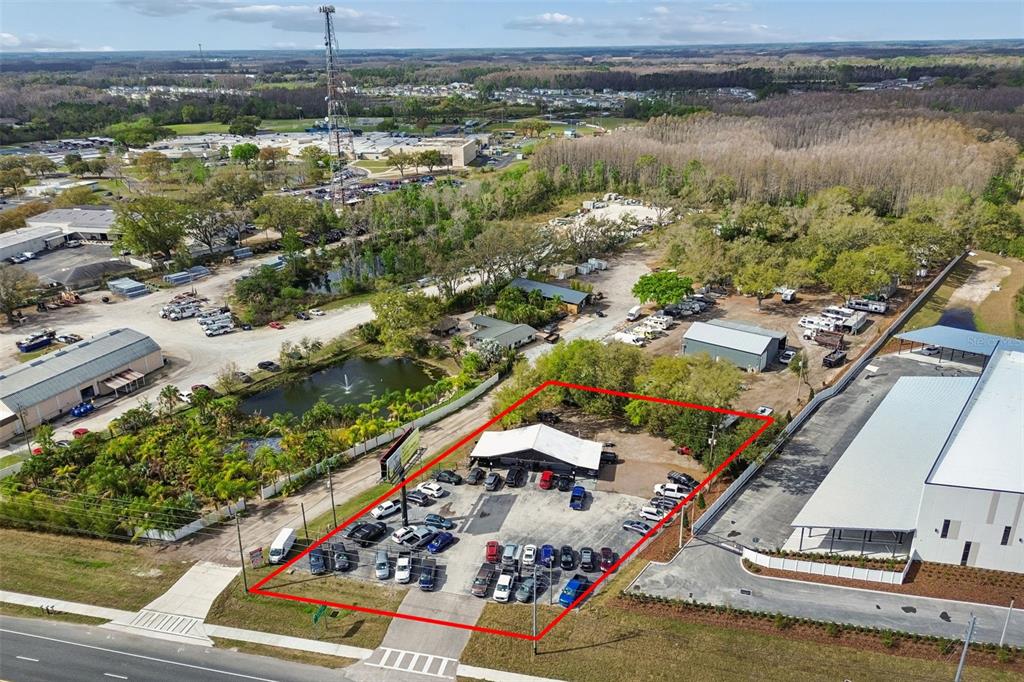 An aerial view shows a commercial property with a building and parking lot outlined in red — 7411 LAND O LAKES BOULEVARD, LAND O LAKES, FL