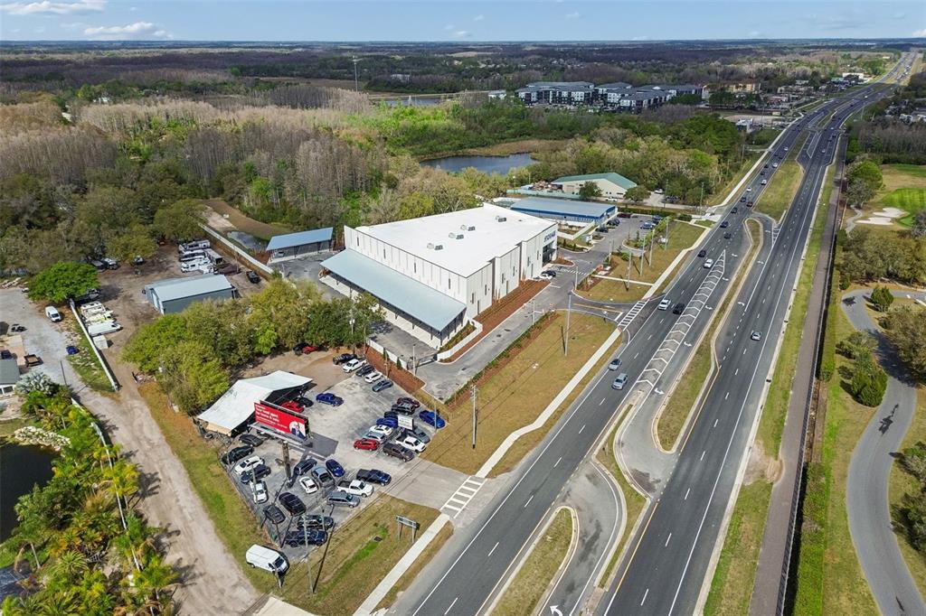 An aerial view shows a commercial building with a parking lot next to a highway — 7411 LAND O LAKES BOULEVARD, LAND O LAKES, FL