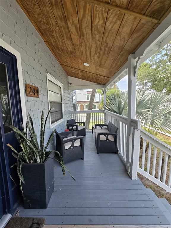 A bedroom features a bed with a tufted headboard, a bay window, and light wood flooring — 244 LEXINGTON DRIVE, DAYTONA BEACH, FL