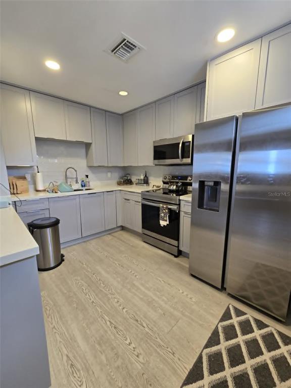 A covered porch with gray wood siding, a wooden ceiling, and a dark front door — 244 LEXINGTON DRIVE, DAYTONA BEACH, FL