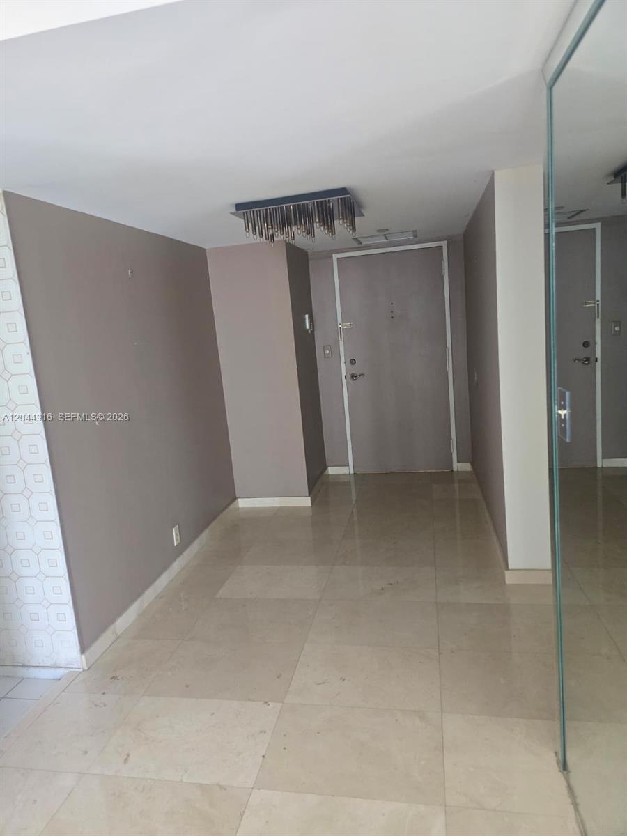 An entryway features light-colored tile flooring, taupe walls, and a modern rectangular ceiling light fixture — 1901 Brickell Ave # B1614, Miami FL 33129, MIAMI, FL