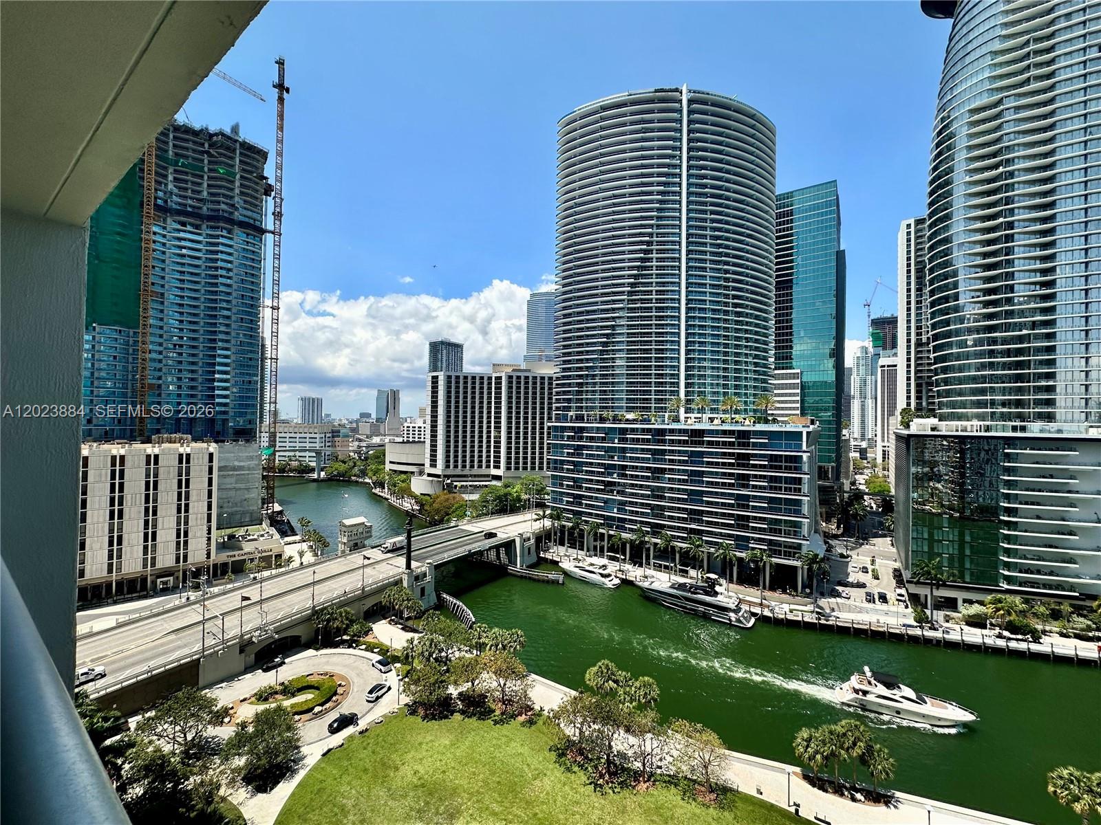 An elevated view of a city skyline featuring skyscrapers, a river, a bridge, and boats — 475 Brickell Avenue # 1614, Miami FL 33131, MIAMI, FL