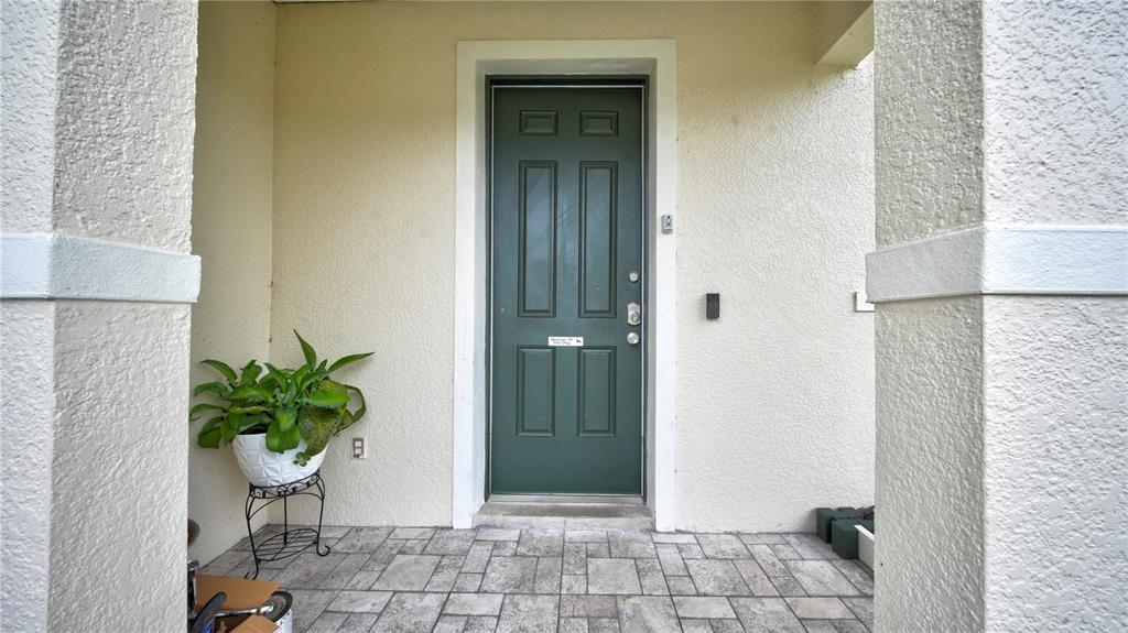 A green front door with a white frame sits on a paved porch — 405 KETTERING ROAD, DAVENPORT, FL