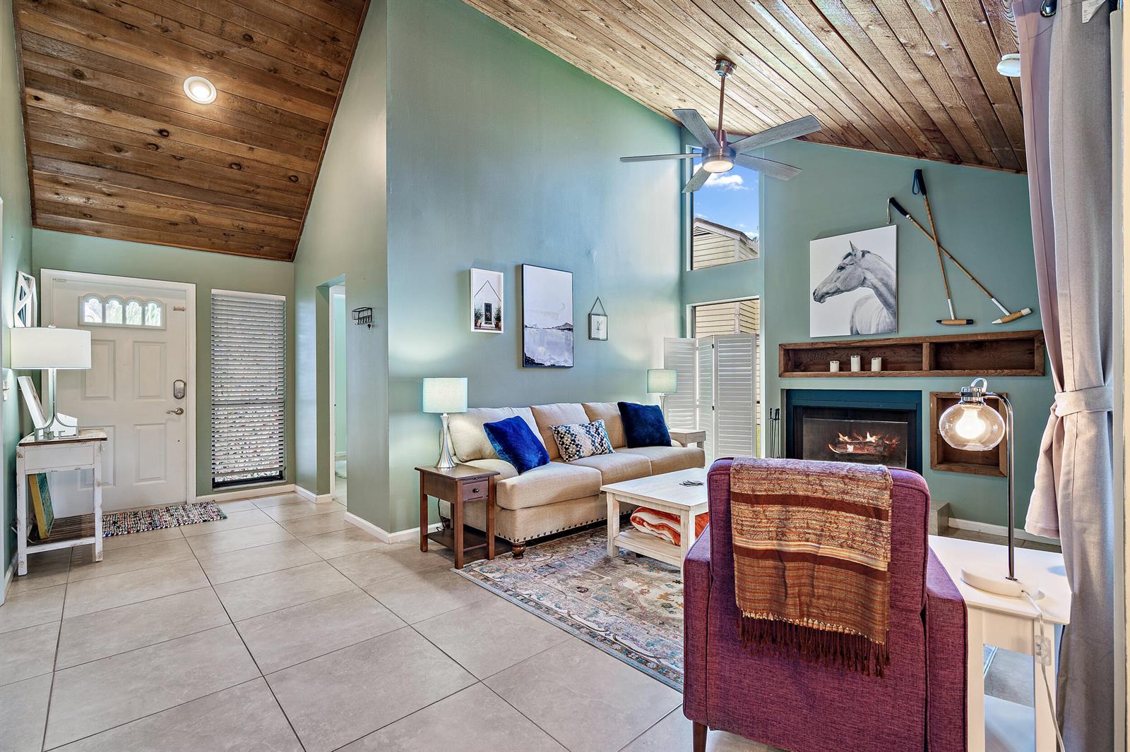 A living room features a vaulted wood ceiling, a fireplace, and a beige sofa — 500 Oak Shadow Way, Wellington FL 33414, WELLINGTON, FL