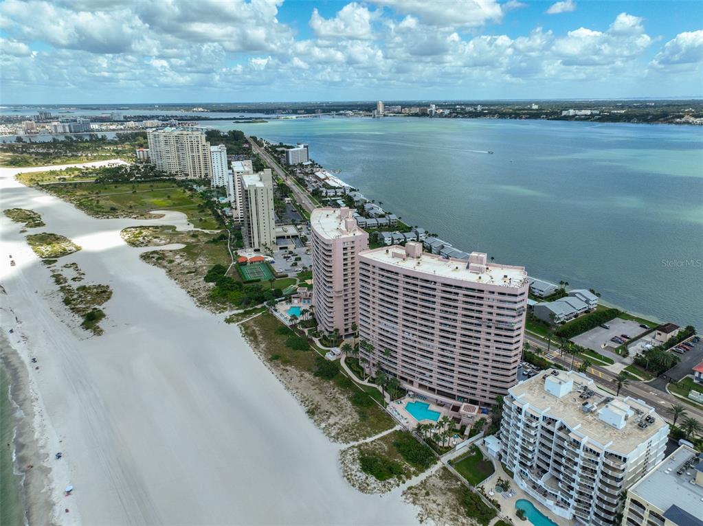 An aerial view of high-rise condominiums situated along a sandy beach and a large bay — 1340 GULF BOULEVARD UNIT 11C, CLEARWATER BEACH, FL