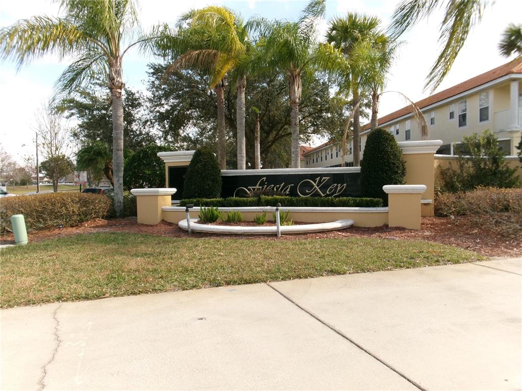 A sign for Fiesta Key stands in front of palm trees and a residential building — 1285 S SOUTH BEACH CIRCLE CIRCLE, KISSIMMEE, FL