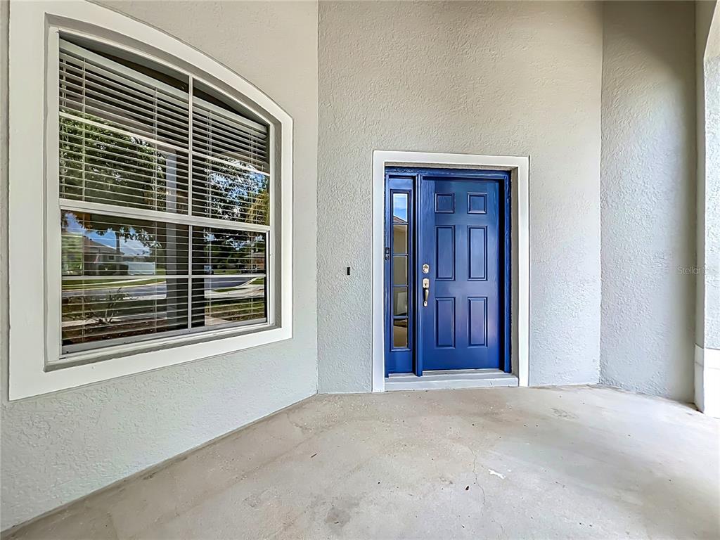 A blue front door with a side light and a large window on a porch — 235 MAGNOLIA PARK TRAIL, SANFORD, FL