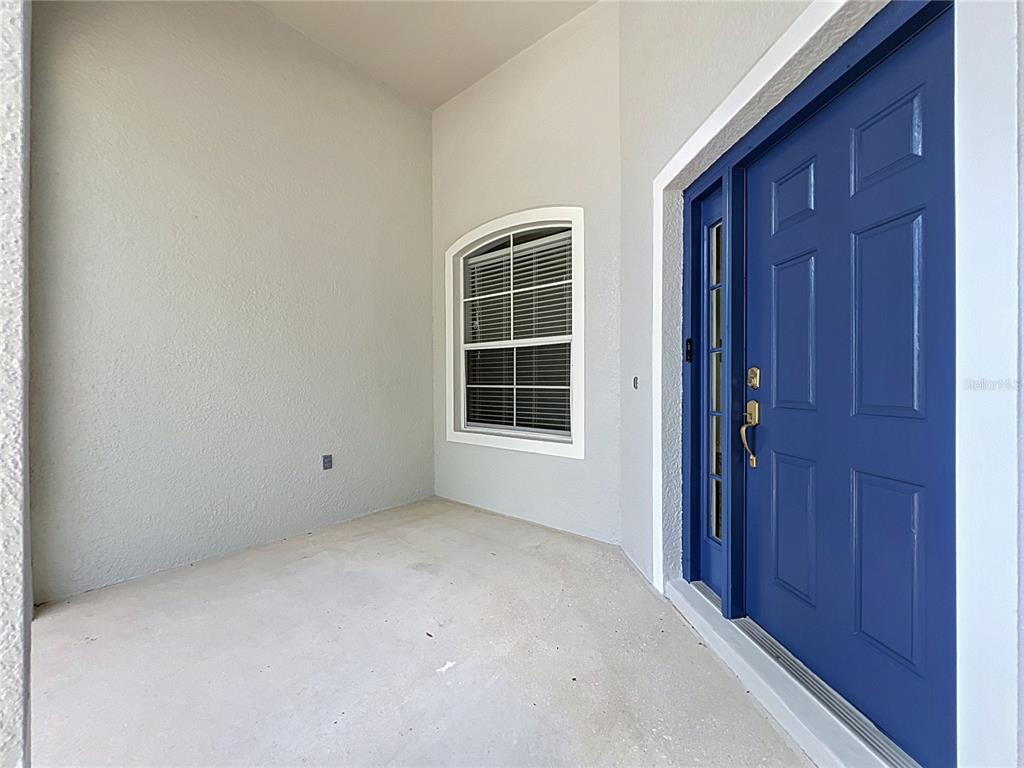 A covered entryway features a blue front door with a sidelight and an arched window — 235 MAGNOLIA PARK TRAIL, SANFORD, FL