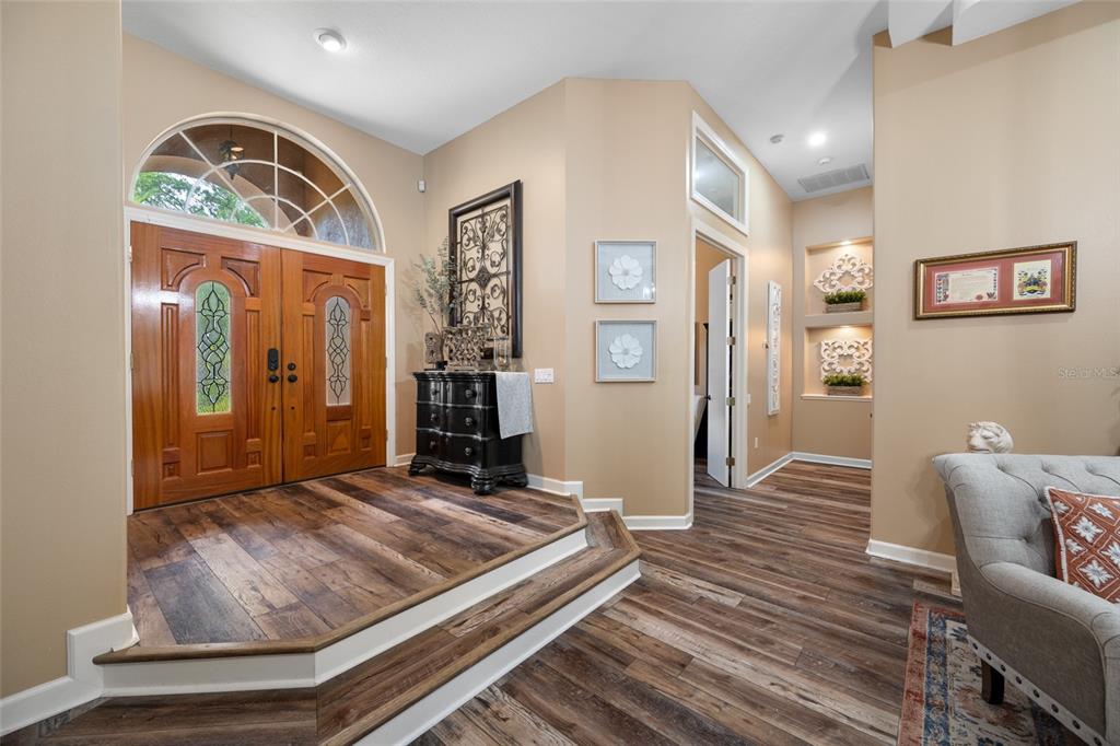 An entryway features a raised wooden platform, double front doors, and light-colored walls — 7888 BAYOU CLUB BOULEVARD, SEMINOLE, FL