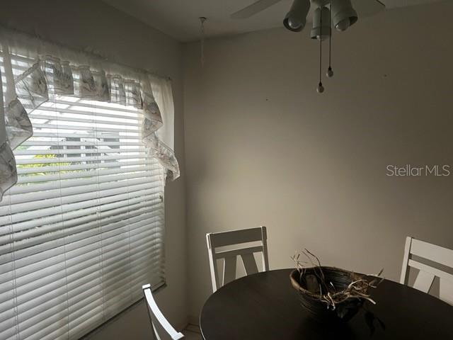 A dining area features a round table, white chairs, and a window with blinds — 8407 OAK JAY LANE, ENGLEWOOD, FL