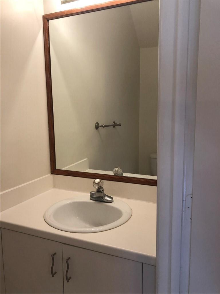 A bathroom vanity features a white countertop, a single sink, and a wood-framed mirror — 3936 San Simeon Lane # 3936, Weston FL 33331, WESTON, FL