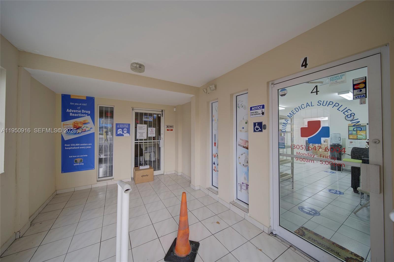 A commercial storefront entrance features a glass door, tiled flooring, and a traffic cone — 330 W 9th St, Hialeah FL 33010, HIALEAH, FL