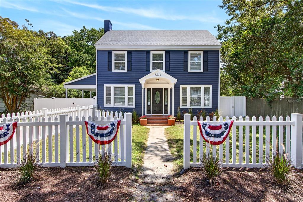 A two-story blue house with white trim and a white picket fence in the front — 1811 SANFORD AVENUE, SANFORD, FL
