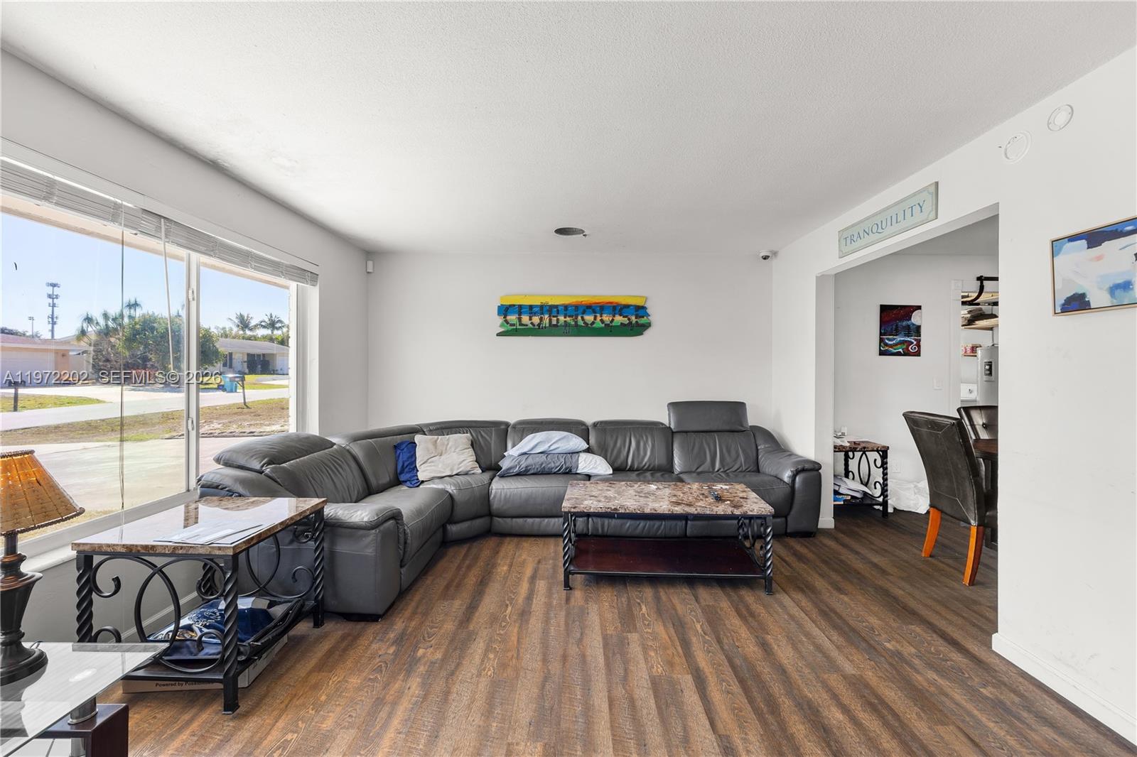 A living room features a grey sectional sofa, a coffee table, and wood-look flooring — 227 SW 13th Ave, Boynton Beach FL 33435, BOYNTON BEACH, FL