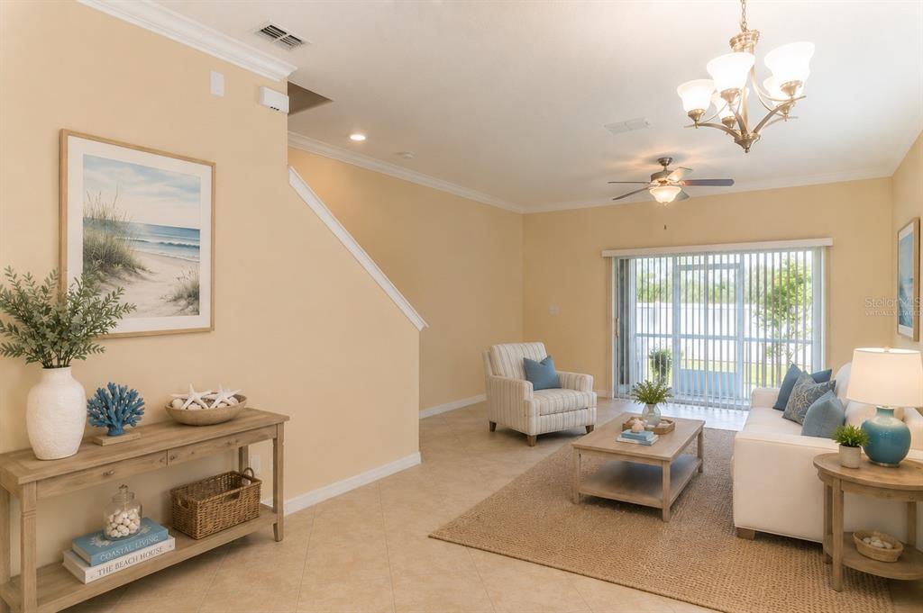 A living room features light-colored tile floors, a beige rug, and coastal-themed decor — 31235 CLARIDGE PLACE, WESLEY CHAPEL, FL
