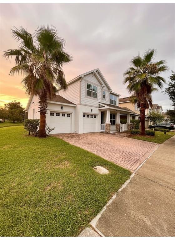 A two-story house with white siding, a brick driveway, and a front porch with columns — 5131 MILLENNIA GREEN DRIVE, ORLANDO, FL