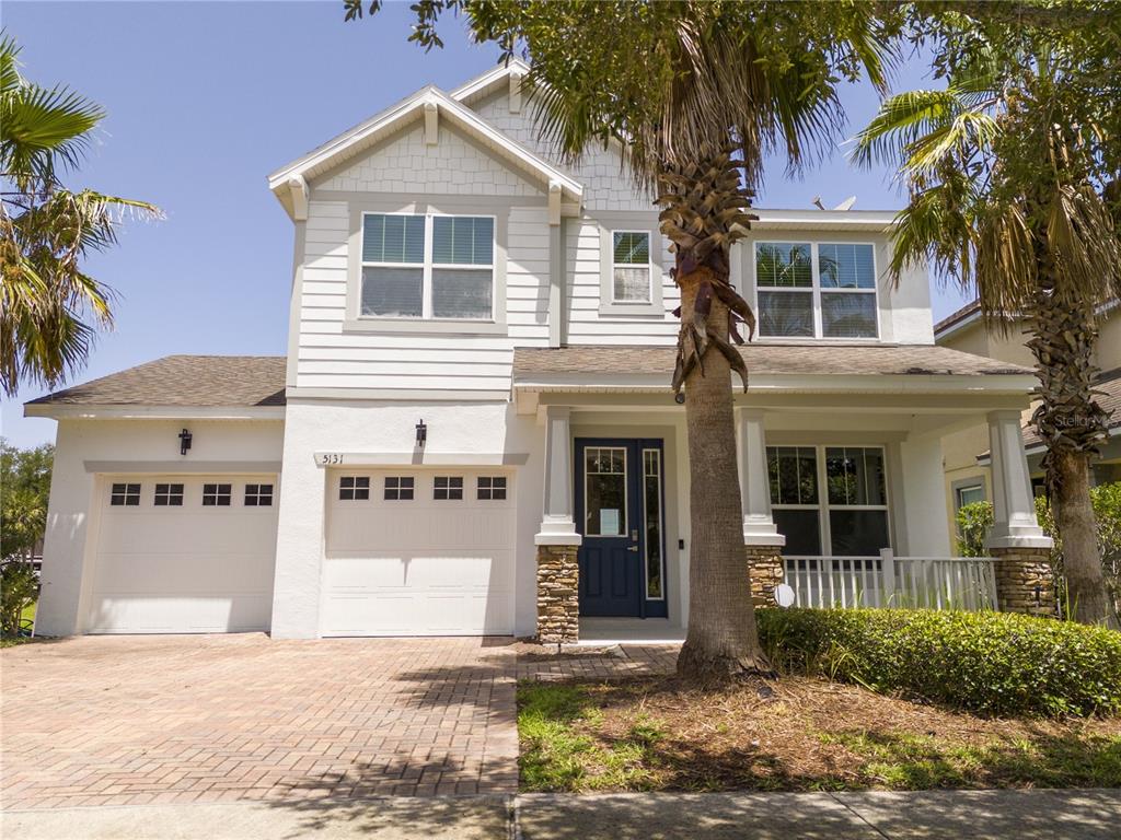 A two-story house with a brick driveway, two garage doors, and two palm trees — 5131 MILLENNIA GREEN DRIVE, ORLANDO, FL