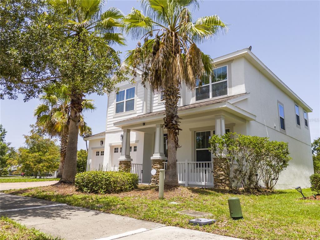 The exterior of a two-story house features a screened-in porch and a large grassy backyard — 5131 MILLENNIA GREEN DRIVE, ORLANDO, FL