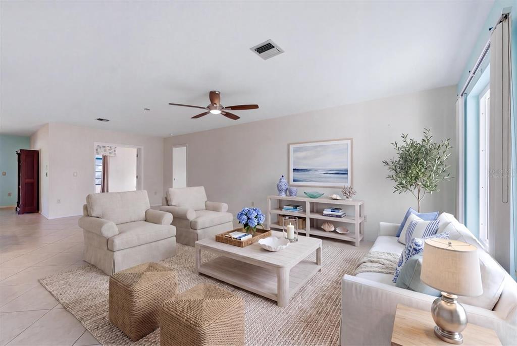 A bright living room features neutral furniture, a light wood coffee table, and a textured rug — 255 RIGEL ROAD, VENICE, FL