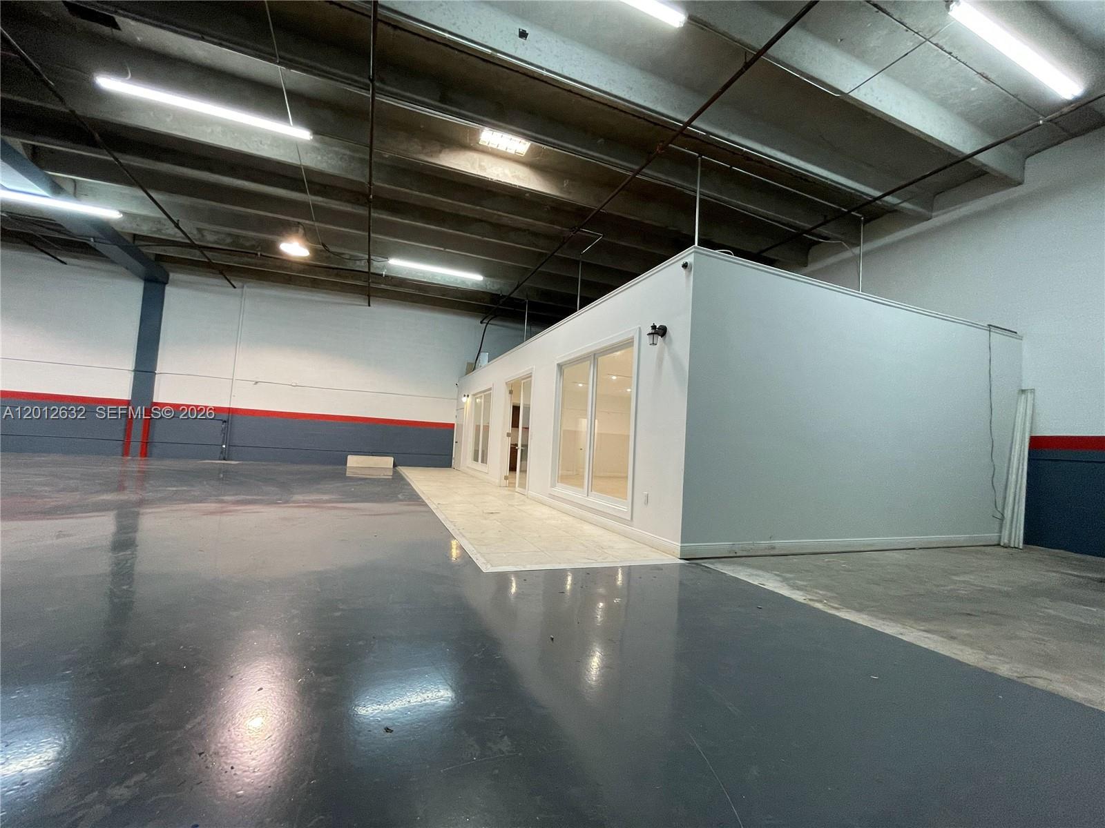A white modular office structure sits inside a large warehouse with a concrete floor — 3004 NW 79th Ave # 3004, Doral FL 33122, DORAL, FL