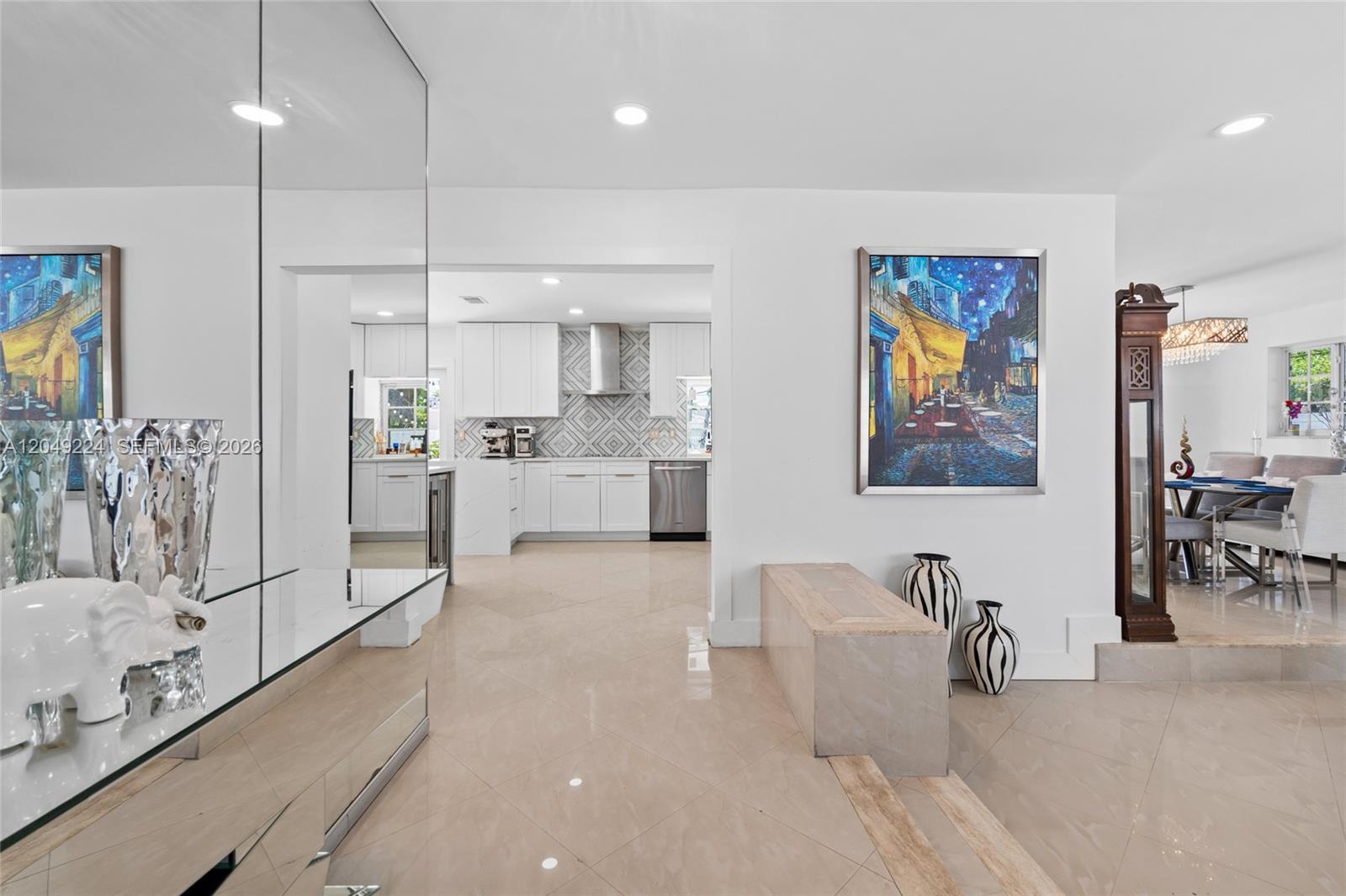 A bright interior features a tiled foyer, a mirrored wall, and a view into the kitchen — 20235 Highland Lakes Blvd, Miami FL 33179, MIAMI, FL