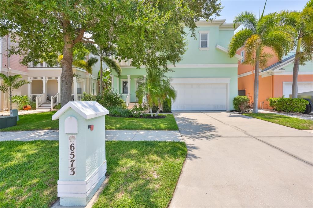 A light green two-story house with a white garage and a matching mailbox in front — 6573 SIMONE SHORES CIRCLE, APOLLO BEACH, FL
