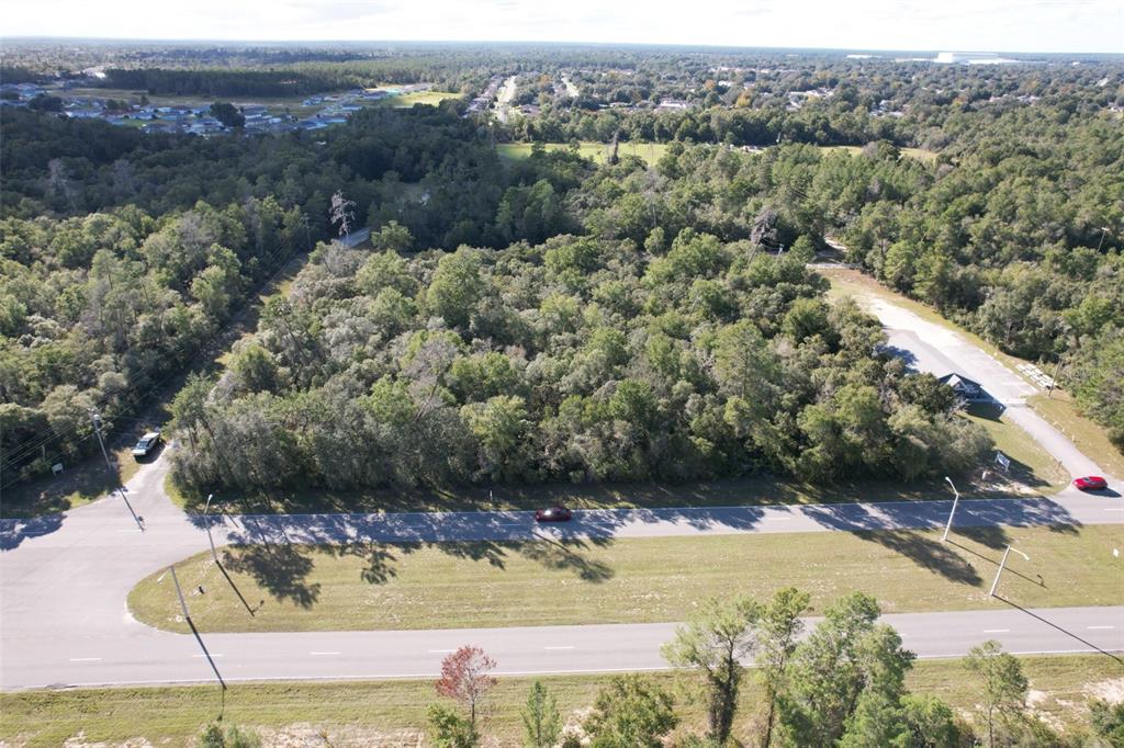An aerial view shows a wooded lot bordered by a road and a parking area — MARION OAKS BOULEVARD, OCALA, FL