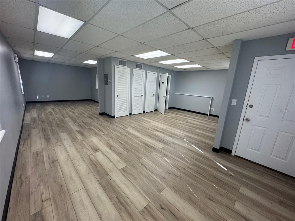 An empty office space features light wood-look flooring, gray walls, and a drop ceiling — 550 N BALMORAL CIRCLE UNIT 108/109, JACKSONVILLE, FL