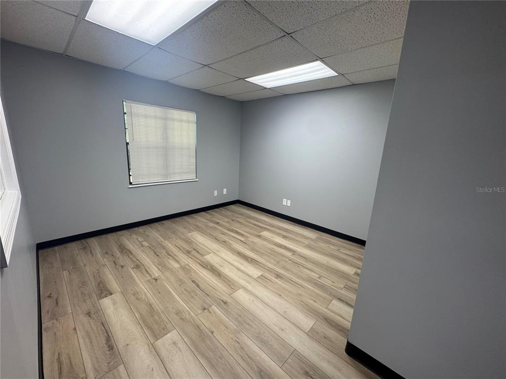 An empty office with gray walls, wood-look flooring, and a drop ceiling with recessed lighting — 550 N BALMORAL CIRCLE UNIT 108/109, JACKSONVILLE, FL