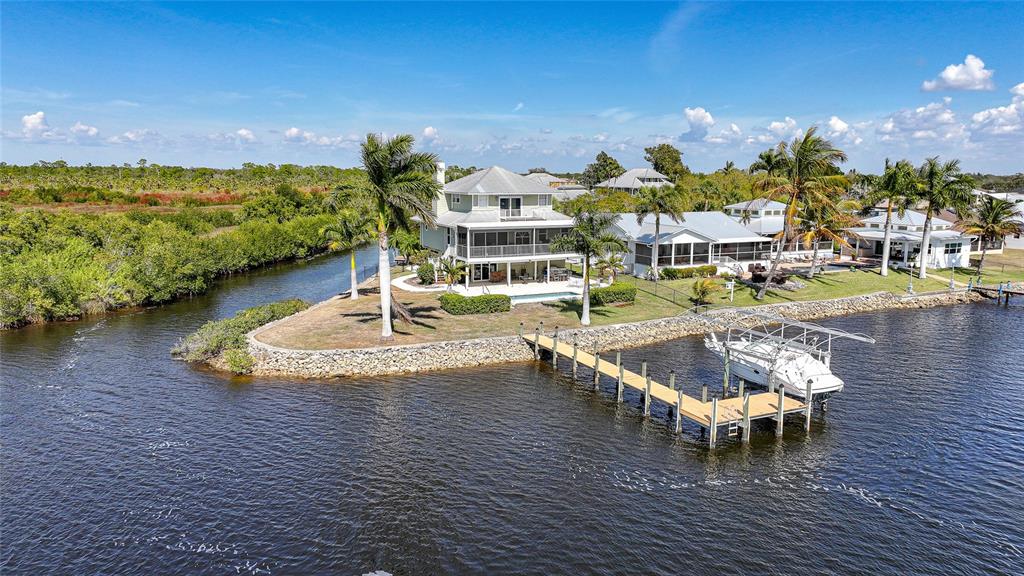 An aerial view of a waterfront house with a private dock and palm trees — 3796 PEACE RIVER DRIVE, PUNTA GORDA, FL