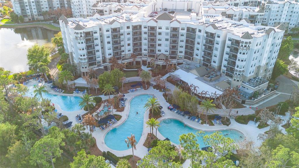 An aerial view shows a large apartment complex with a multi-section swimming pool and landscaping — 14501 GROVE RESORT AVENUE UNIT 1629, WINTER GARDEN, FL
