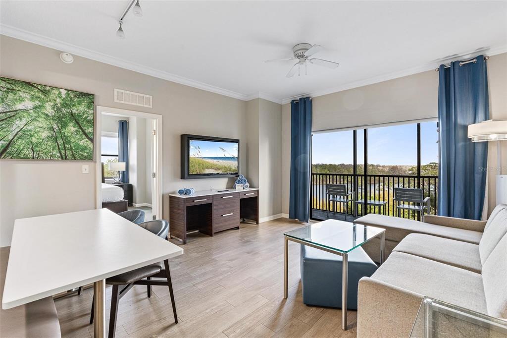 A living room with a dining area, a sofa, a television, and a balcony view — 14501 GROVE RESORT AVENUE UNIT 1629, WINTER GARDEN, FL